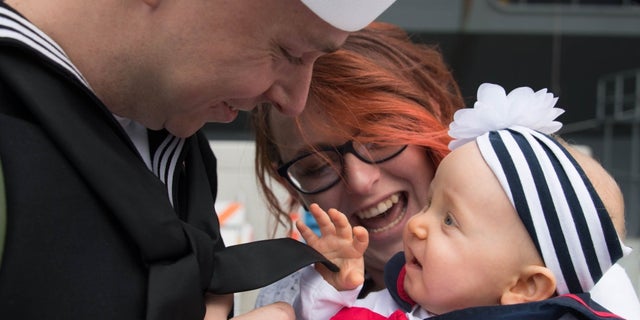 USS Abraham Lincon Machinist's Mate Ryan Herman met his daughter in the arms of his wife for the first time.