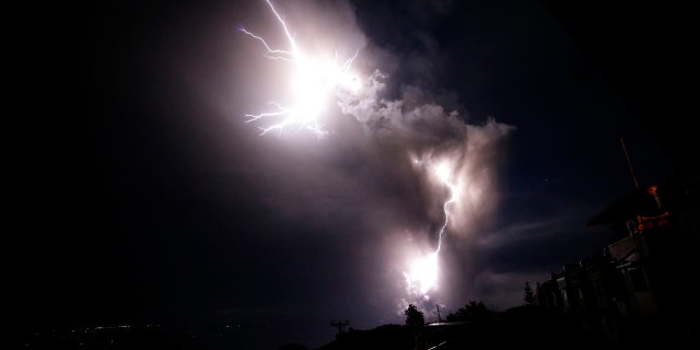 Lightning strikes beside the ash cloud as Taal Volcano erupts Sunday Jan. 12, 2020, in Tagaytay, Cavite province, outside Manila, Philippines.