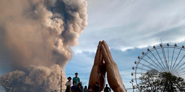 People watch as the Taal volcano spews ash and smoke during an eruption in Tagaytay, Cavite province south of Manila, Philippines on Sunday. Jan. 12, 2020.
