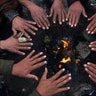 People sit around a fire to warm themselves after a snowfall in Kabul, Afghanistan, Jan. 14, 2020. 