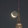 A crescent moon rises in the pre-dawn sky behind the Empire State Building and its 102nd-floor observation deck in New York City, Jan. 21, 2020.