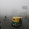 A cyclist pedals across a crossing amidst early morning dense fog in New Delhi, India, Dec. 30, 2019. 