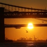 The sun sets behind the Manhattan Bridge, Brooklyn Bridge and Statue of Liberty in New York City, Jan29, 2020.