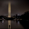 The Washington Monument, partially obscured by late evening fog, is visible as a man stands at the Reflecting Pool in Washington, Dec. 29, 2019. 