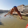 Marco Fois dives into the Tiber river from the 59 foot high Cavour Bridge in Rome, Jan. 1, 2020. 