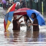 People wade through floodwaters at Jatibening on the outskirt of Jakarta, Indonesia, Jan. 1, 2020. 