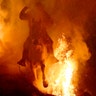 A man rides a horse through a bonfire as part of a ritual in honor of Saint Anthony the Abbot, the patron saint of domestic animals, in San Bartolome de Pinares, Spain, Jan. 16, 2020. 
