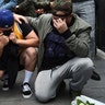 Los Angeles Laker fans Alex Fultz, from left, Eddy Rivas and Rene Alfaro mourn retired NBA star Kobe Bryant outside of the Staples Center prior to the 62nd annual Grammy Awards.