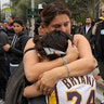 Elana Hirschman, left, hugs her son Bryan, 11, as her husband Craig stands by at the scene of a helicopter crash Bryant and as many as eight others.