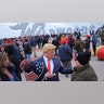 Tim Carney, dressed as President Trump, talking with people near the boardwalk before the start of the campaign rally.