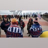 Supporters of President Donald Trump stand near the iconic Wildwoods sign as they wait to enter the campaign rally.