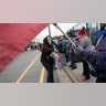 A woman selling buttons to people standing in line near the Wildwoods Convention Center.