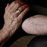 In this Wednesday, Jan. 8, 2020 photo Auschwitz survivor Eva Umlauf shows her tattoed arm as she poses for a photo in Munich, Germany. 