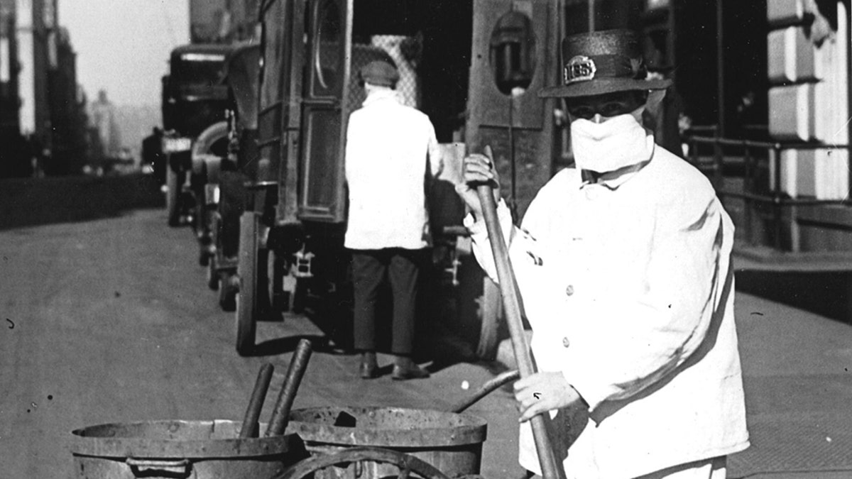 A New York city street sweeper wears a mask to help check the spread of the influenza epidemic, October 1918. In the view of one official of the New York Health Board, it is 'Better be ridiculous, than dead'. (Photo by PhotoQuest/Getty Images)