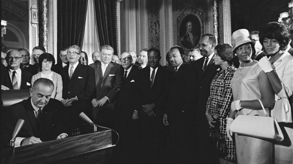 President Lyndon Johnson signing the Voting Rights Act which enforced the 15th Amendment. 