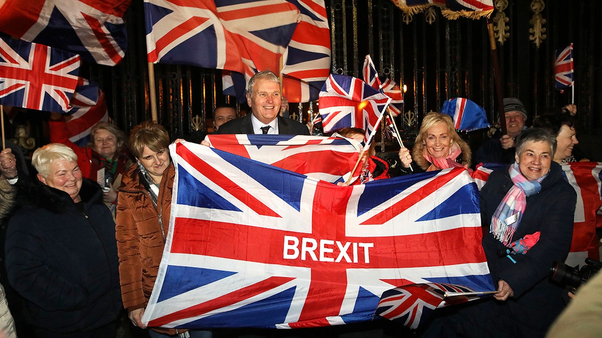 Brexit supporters celebrate during a rally outside Stormont in Belfast, Northern Ireland as Britain left the European Union on Friday, Jan. 31, 2020. Britain officially left the European Union on Friday after a debilitating political period that has bitterly divided the nation since the 2016 Brexit referendum. (AP Photo/Peter Morrison)