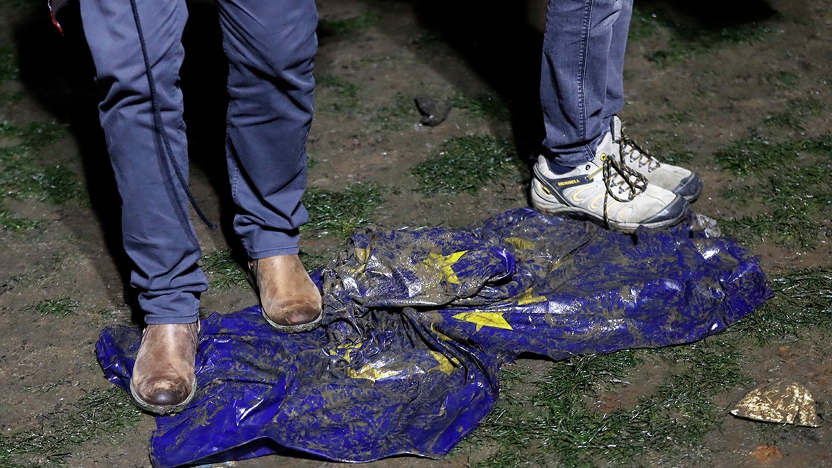 Brexit supporters trample on a European Union flag during a rally in London, Friday, Jan. 31, 2020. Britain officially leaves the European Union on Friday after a debilitating political period that has bitterly divided the nation since the 2016 Brexit referendum. (AP Photo/Frank Augstein)