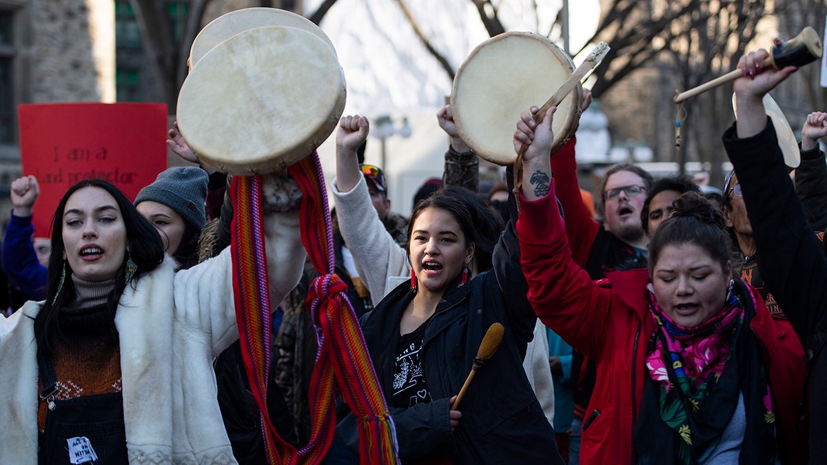 People raise their hands and drums as they rally in solidarity with Wet'suwet'en hereditary chiefs opposed to the Costal GasLink Pipeline, in Ottawa, on Monday, Feb. 24, 2020. (Justin Tang/The Canadian Press via AP)