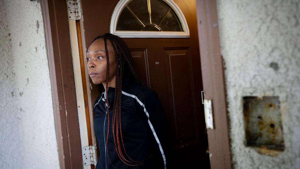 Latosha Evans, a friend of Myon Burrell who says she was with the Burrell the evening Tyesha Edwards was shot and killed at home in 2002, stands in her doorway, Wednesday, Oct. 23, 2019, in Minneapolis. (Associated Press)