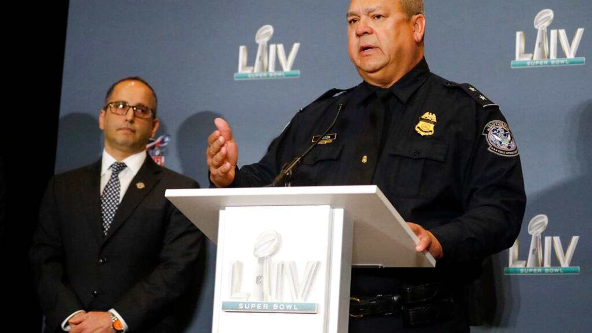 Christopher D. Maston, U.S. Customs and Border Protection, Miami International Airport Port Director, right, speaks as Steve K. Francis, Global Trade Investigations Division Assistant Director and National Intellectual Property Rights Coordination Center Director looks on, during news conference about seized counterfeit merchandise and tickets related to the NFL Super Bowl 54 football game, Thursday, Jan. 30, 2020, in Miami Beach, Fla. (AP Photo/Chris Carlson)