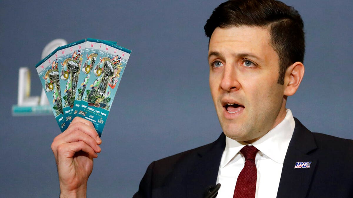 Michael Buchwald, NFL Senior Counsel, holds up authentic tickets for the NFL Super Bowl 54 football game during a news conference about seizures of counterfeit game-related merchandise and tickets, Thursday, Jan. 30, 2020, in Miami Beach, Fla. (AP Photo/Chris Carlson)
