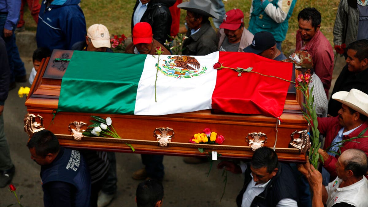 Mourners carry the flag-draped coffin of community activist Homero Gomez Gonzalez as the funeral procession makes its way from the church to a hillside cemetery, in Ocampo, Michoacan state, Mexico, Friday, Jan. 31, 2020. Hundreds of farmers and agricultural workers attended the funeral Friday, and the homage to the anti-logging activist was like a tribute to the monarch butterfly he so staunchly defended. (AP Photo/Rebecca Blackwell)