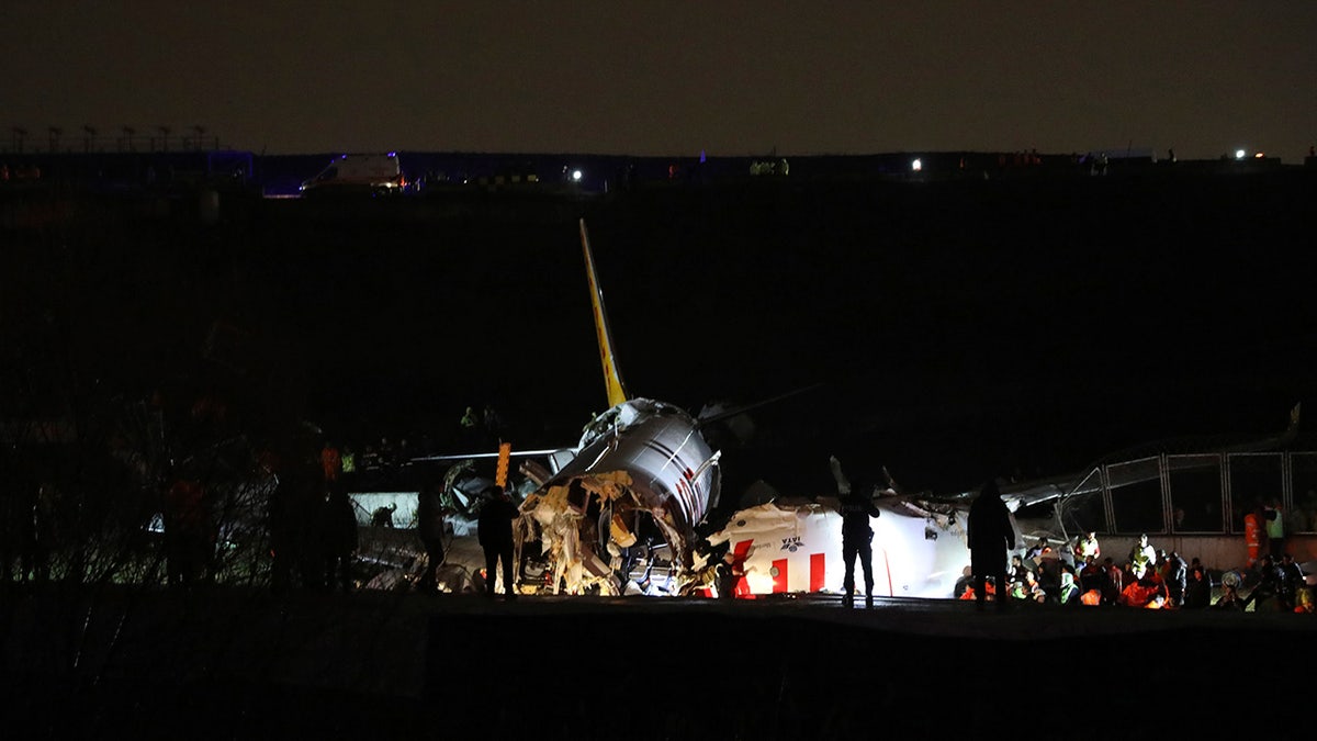 Rescue members working after the plane skidded off the runway in Istanbul. (AP)