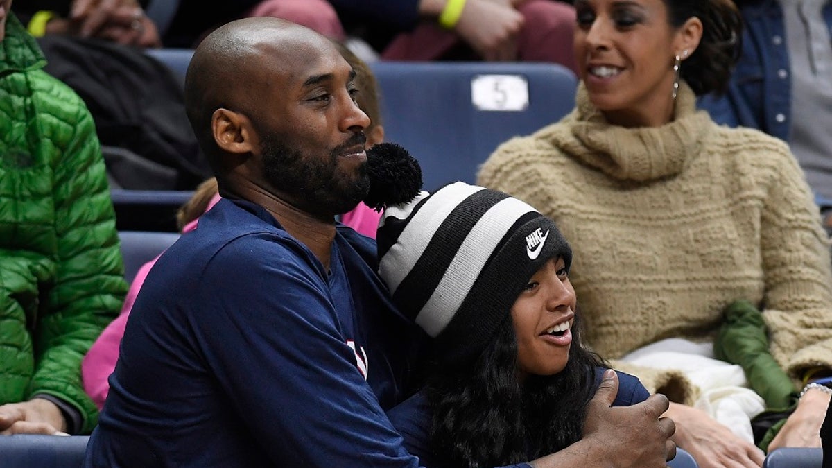 Kobe Bryant and his daughter Gianna watch the first half of an NCAA college basketball game between Connecticut and Houston in Storrs, Conn. (AP Photo/Jessica Hill, File)