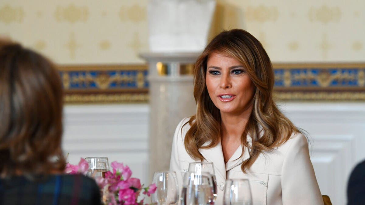 First lady Melania Trump sits down at her table after speaking during the Governors' Spouses' luncheon in the Blue Room of the White House in Washington, Monday, Feb. 10, 2020. (AP Photo/Susan Walsh)