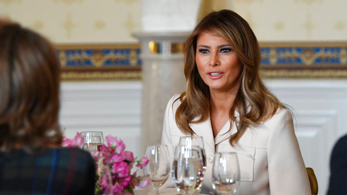First lady Melania Trump sits down at her table after speaking during the Governors' Spouses' luncheon in the Blue Room of the White House in Washington, Monday, Feb. 10, 2020. (AP Photo/Susan Walsh)