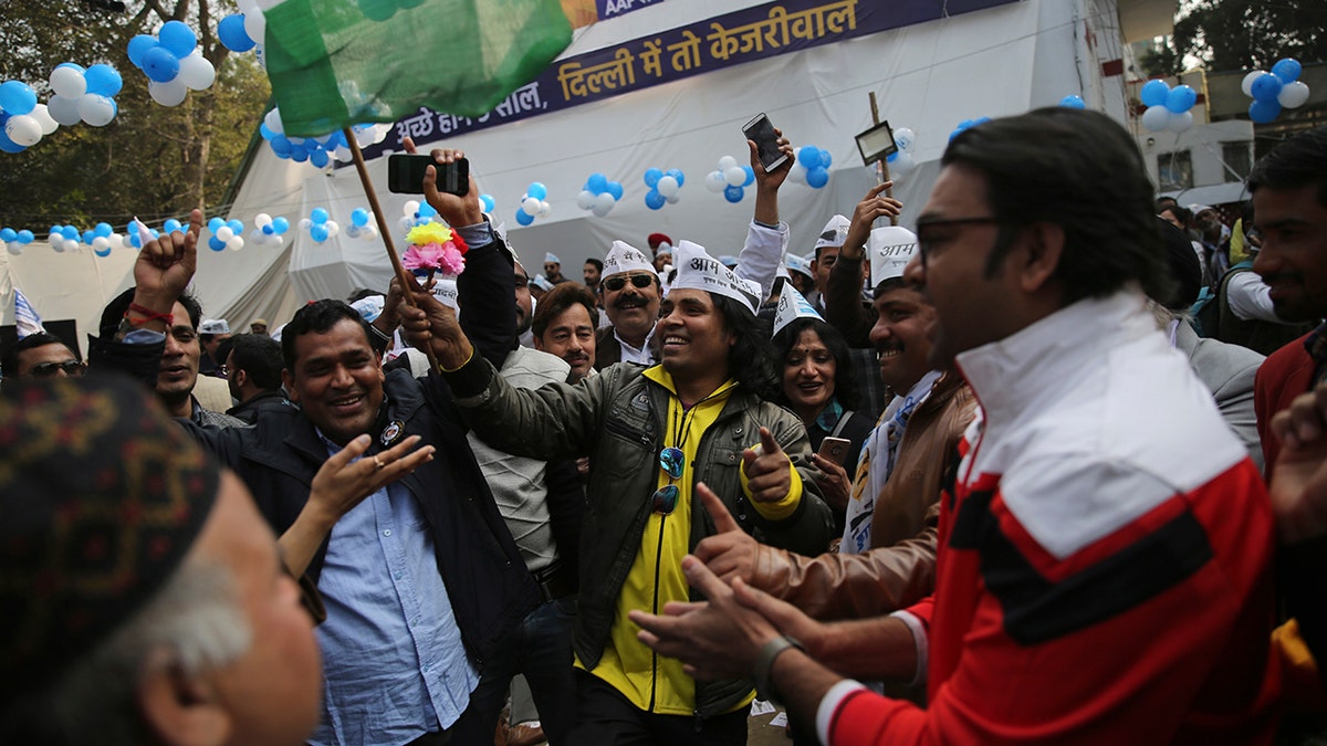 Supporters of the Aam Aadmi Party, or "common man's" party, celebrate as initial results show the party in the lead, at their party office in New Delhi, India, Tuesday, Feb. 11, 2020. The polls put Indian Prime Minister Narendra Modi's Bharatiya Janata Party against the incumbent Aam Aadmi Party, whose pro-poor policies have focused on fixing state-run schools and providing free health care and bus fares for women during the five years in power. (AP Photo/Altaf Qadri)