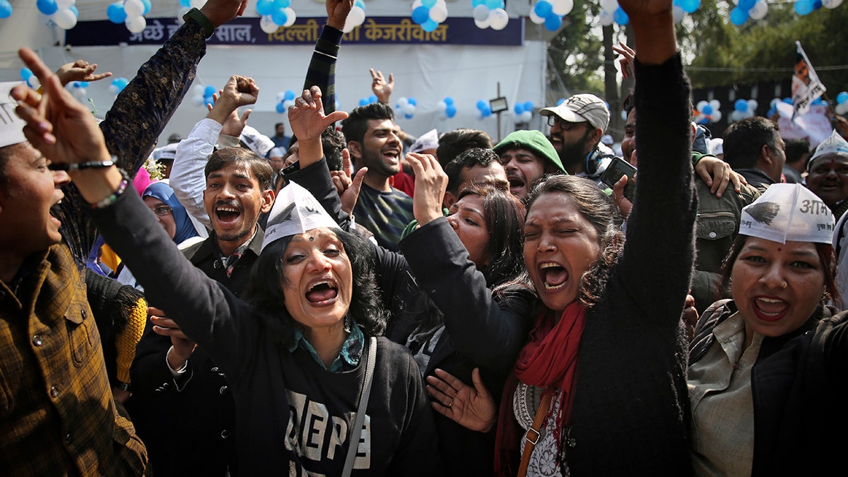 Supporters of the Aam Aadmi Party, or "common man's" party, celebrate the party's victory, at their party office in New Delhi, India, Tuesday, Feb. 11, 2020. The polls put Indian Prime Minister Narendra Modi's Bharatiya Janata Party against the incumbent Aam Aadmi Party, whose pro-poor policies have focused on fixing state-run schools and providing free health care and bus fares for women during the five years in power. (AP Photo/Altaf Qadri)