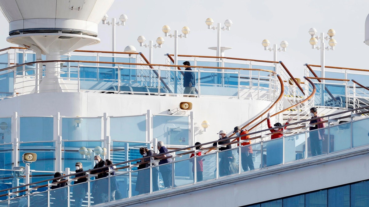 Passengers stand on the deck of the Diamond Princess cruise ship anchored at Yokohama Port. (Yuta Omori/Kyodo News via AP)