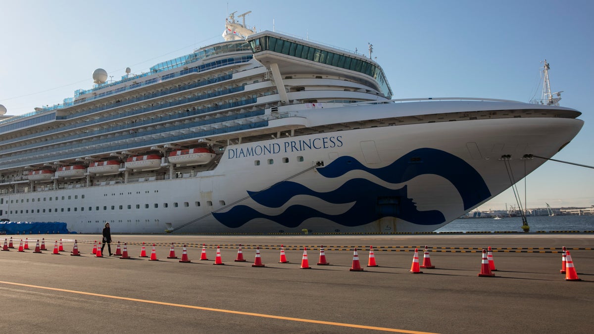 In this Feb. 11 photo, a reporter walks near the then-quarantined Diamond Princess cruise ship in Yokohama, near Tokyo. (AP Photo/Jae C. Hong, File)