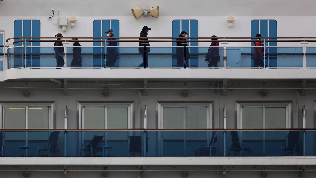 A group of quarantined passengers exercise on the Diamond Princess cruise ship Saturday, Feb. 15, 2020, in Yokohama, near Tokyo. A viral outbreak that began in China has infected more than 67,000 people globally. The World Health Organization has named the illness COVID-19, referring to its origin late last year and the coronavirus that causes it. (AP Photo/Jae C. Hong)