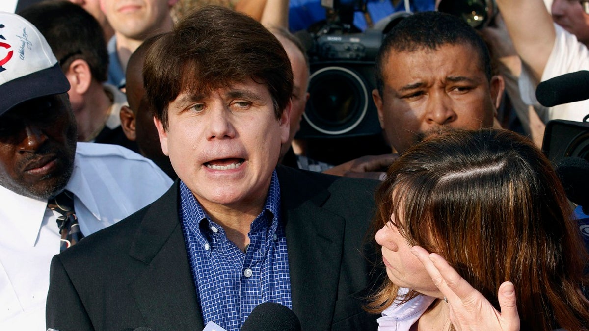 In this March 14, 2012, file photo, former Illinois Gov. Rod Blagojevich speaks to the media outside his home in Chicago as his wife, Patti, wipes away tears a day before reporting to prison after his conviction on corruption charges. (AP Photo/M. Spencer Green, File)