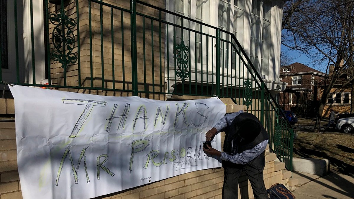 Ziff Sistrunk of Chicago places a sign of support in front of the home of Patti Blagojevich, wife of former Illinois Gov. Rod Blagojevich, in the Ravenswood neighborhood of Chicago on Tuesday, Feb. President Donald Trump commuted the 14-year prison sentence of Blagojevich Tuesday, calling the sentence "ridiculous." (AP Photo/Charles Rex Arbogast)