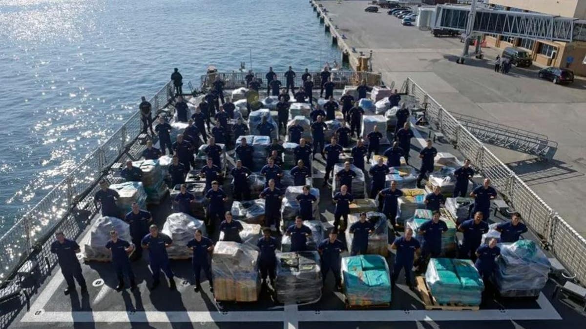 Members of the Coast Guard cutter Hamilton stand next to more than two dozens tons of cocaine. 