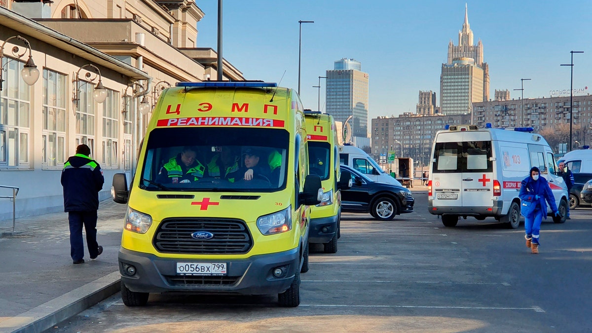 In this file photo taken on Friday, Feb. 21, 2020, Ambulance cars are parked while medics check passengers where a passenger was identified with suspected coronavirus after arriving from Kyiv at Kievsky rail station in Moscow, Russia.