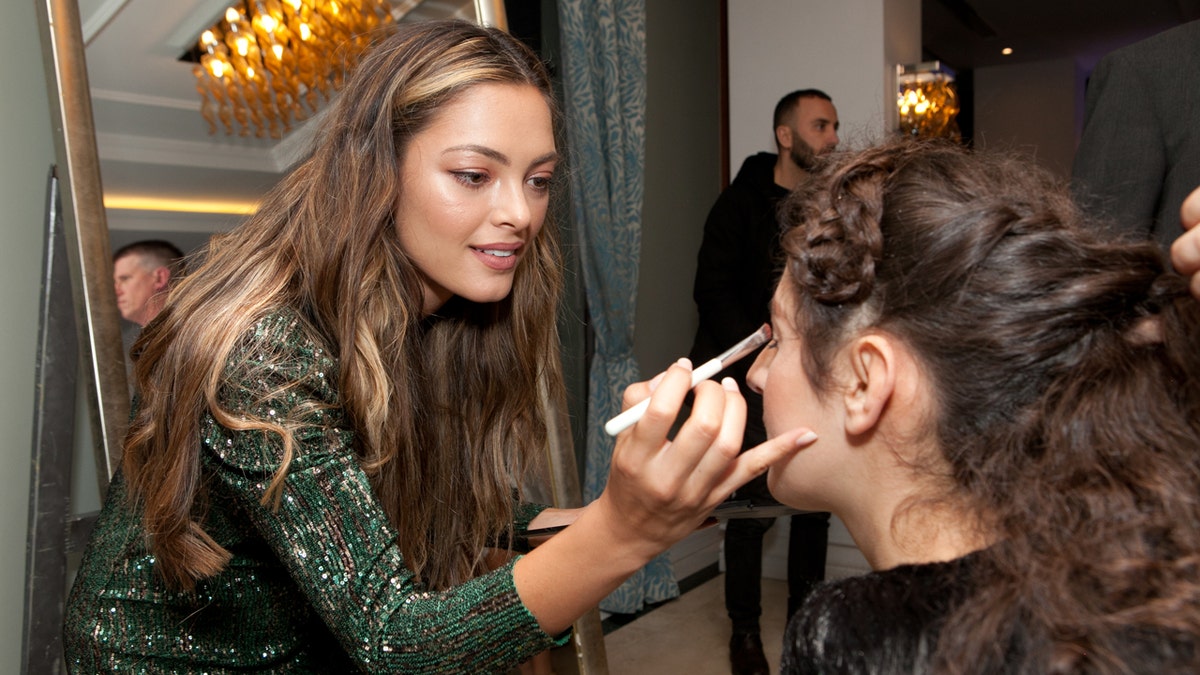 Demi-Leigh Nel-Peters puts makeup on one of the guests at the "Night to Shine" in Albania.