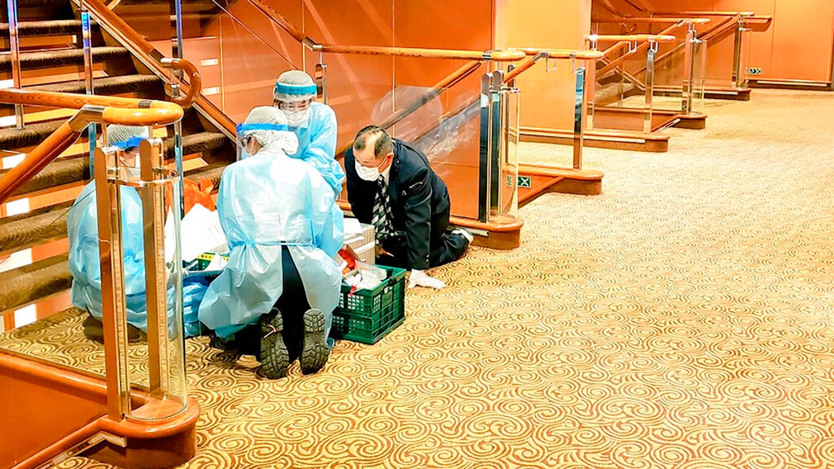 Medical workers in protective suits are seen aboard the Diamond Princess earlier this week.