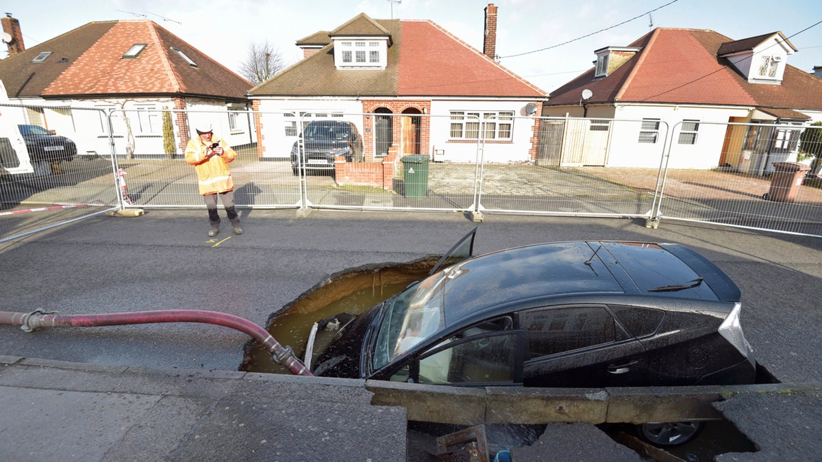 A view of a Toyota car in a sinkhole which appeared overnight in the aftermath of Storm Ciara, in Brentwood, England, Monday, Feb. 10, 2020.