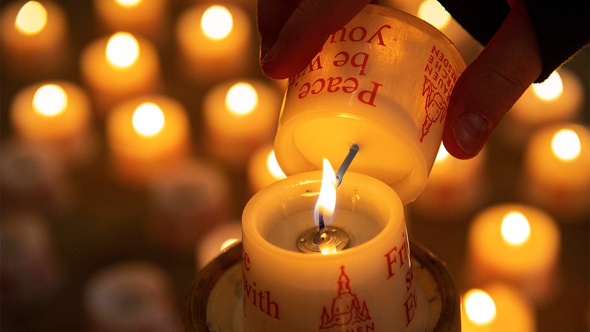 A child lights a candle in the Frauenkirche cathedral (Church of Our Lady) in Dresden, Germany. (AP Photo/Jens Meyer)