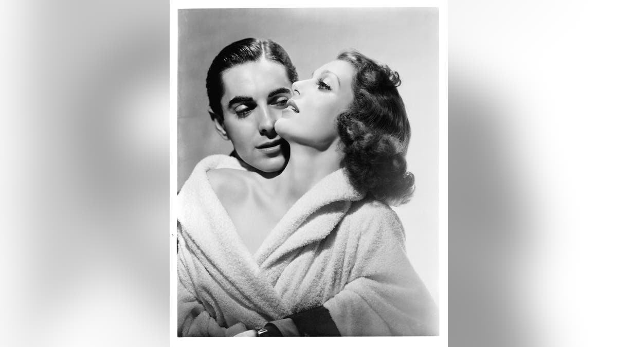 Tyrone Power holds Loretta Young in publicity portrait for the film 'Love Is News', 1937.