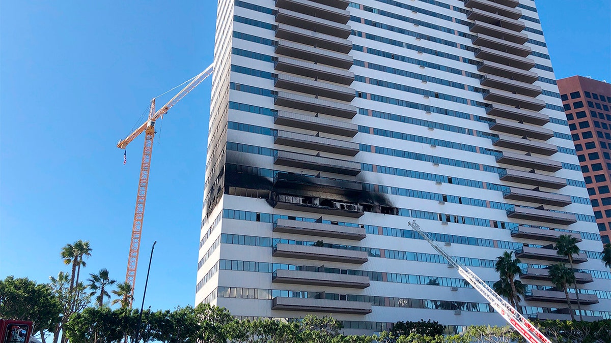 A Los Angele Fire Department ladder stands at the side of a 25-story high-rise apartment building where a fire broke out on a sixth-floor balcony and sent choking smoke billowing through the upper levels in West Los Angeles Wednesday, Jan. 29, 2020. (AP Photo/Stafanie Dazio)