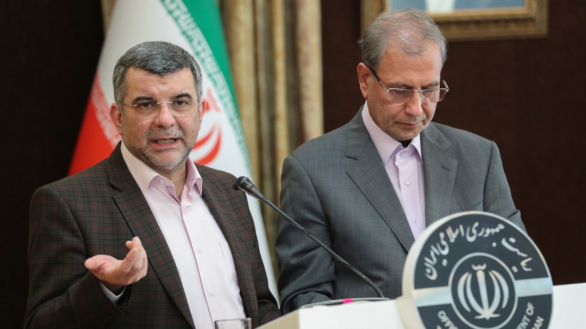 Iraj Harirchi, left, speaks at a press briefing on Monday with government spokesman Ali Rabiei, in Tehran, a day before he released a video saying that he tested positive for the virus. 