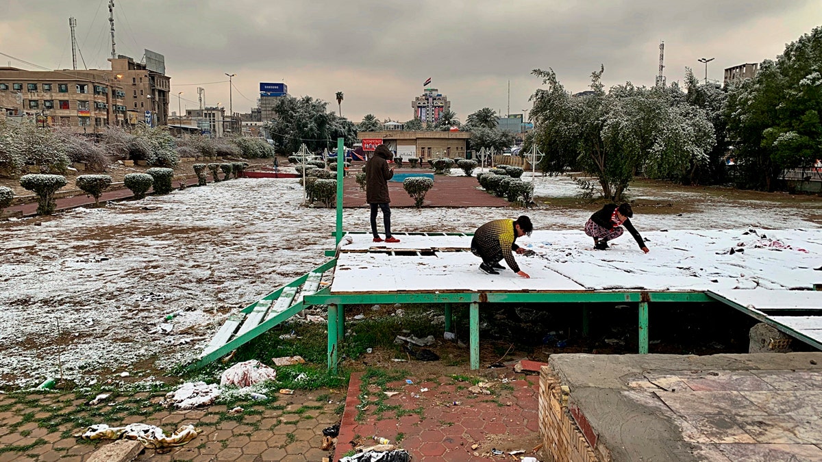 People play in the fresh snow in Baghdad, Iraq, Tuesday, Feb. 11, 2020.