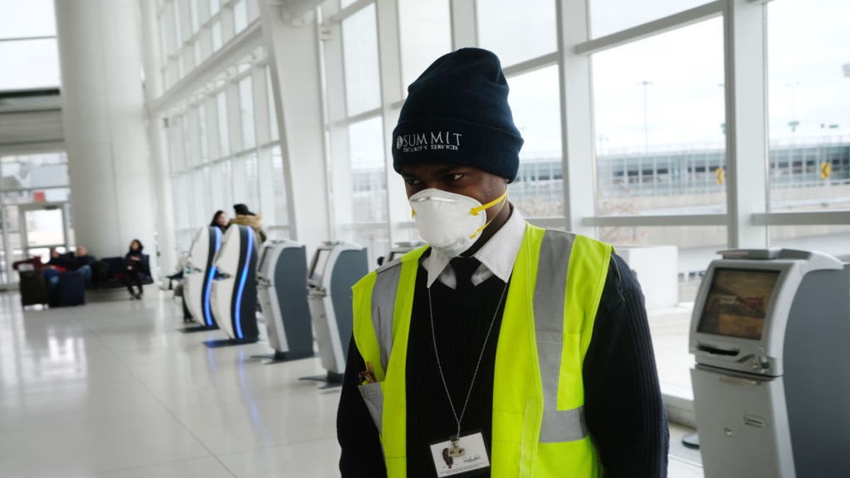An airport employee working at JFK is seen wearing a mask on Friday, Jan. 31, out of concern over the coronavirus outbreak.