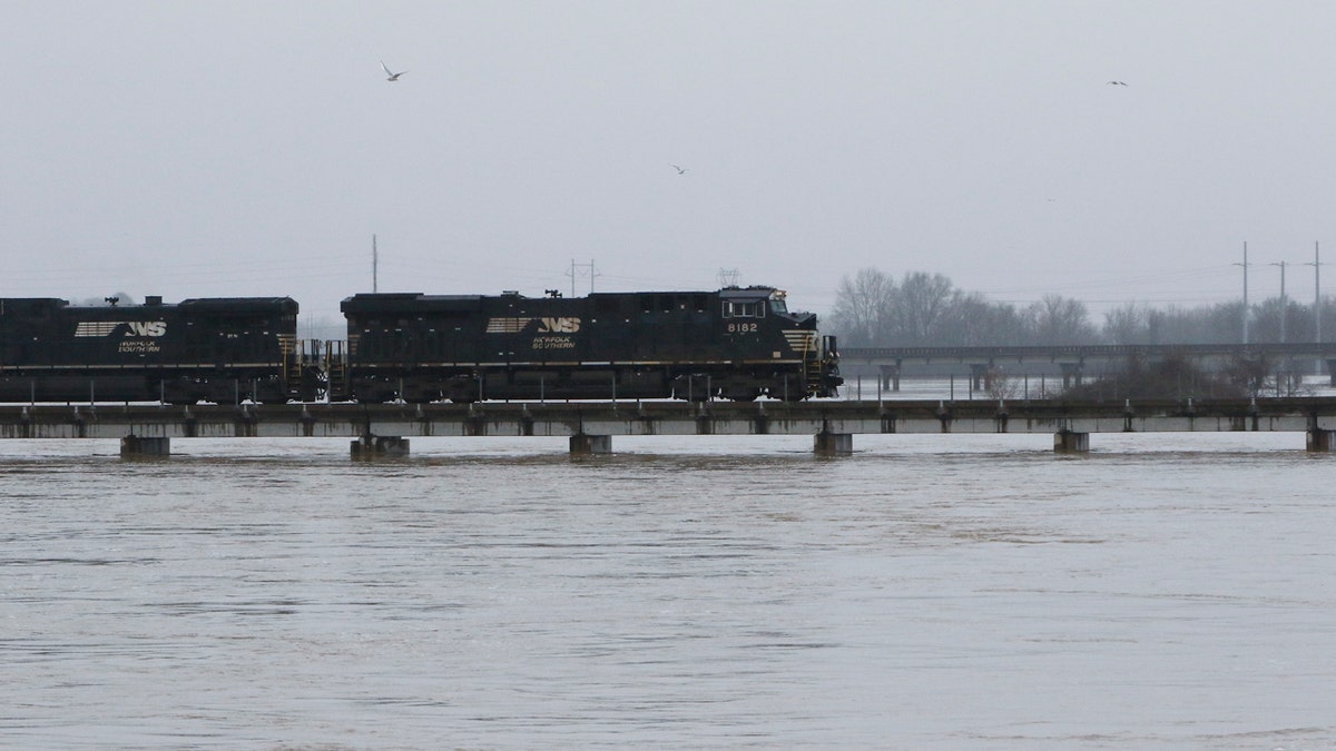 A freight train rolls over the swollen Pearl River towards Jackson, Miss., Sunday, Feb. 16, 2020.