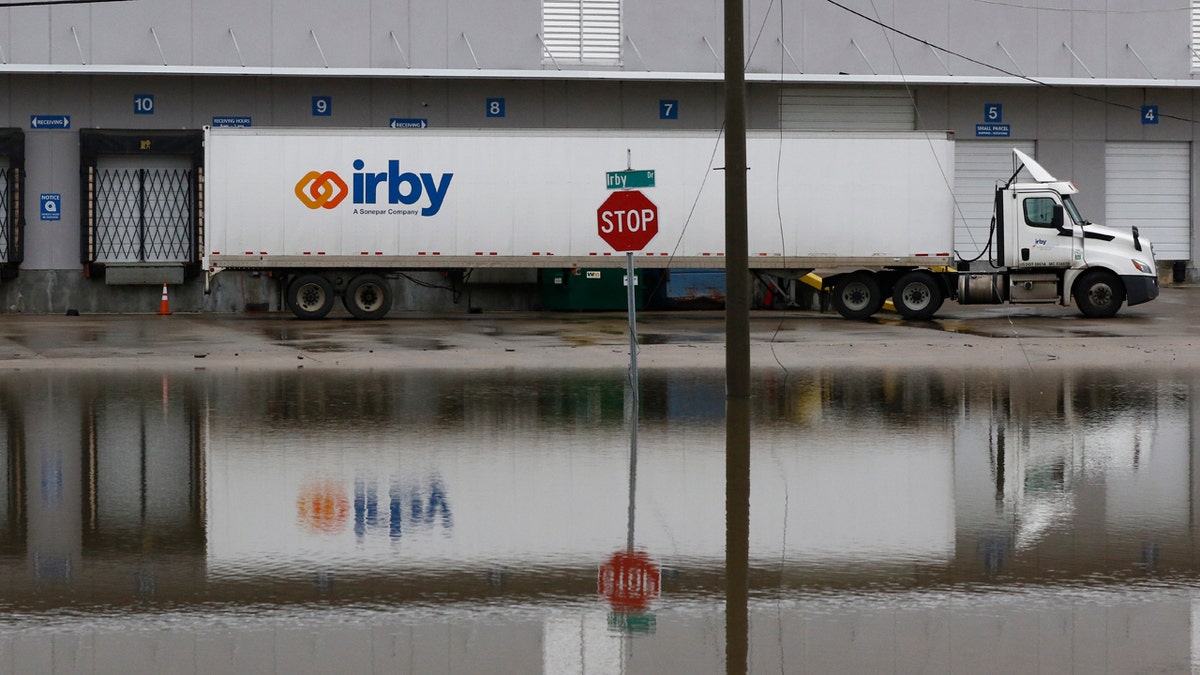 A parked tractor trailer's reflection is seen on a flooded street in downtown Jackson, Miss., as flooding from the Pearl River continues to impact several communities along its bank, Sunday, Feb. 16, 2020.